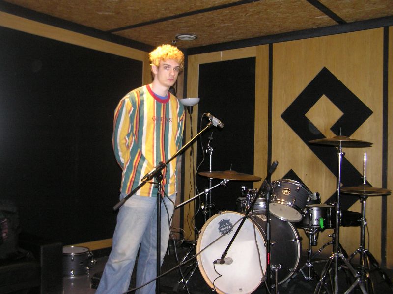 Tom in front of a drum kit